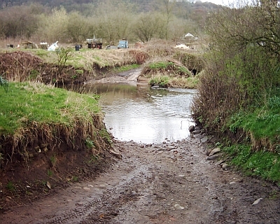 a muddy track leading to a deep river